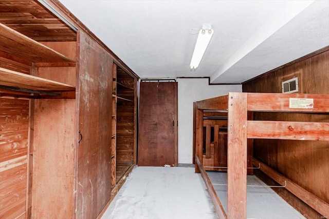 bedroom featuring wood walls