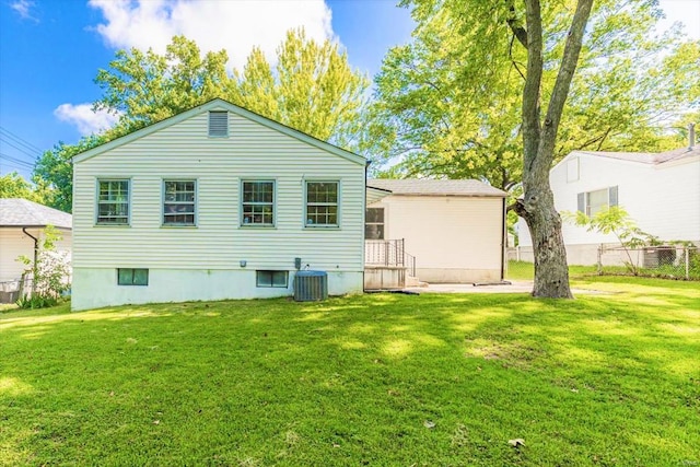 rear view of property with a lawn and central AC