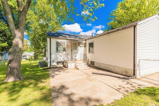 exterior space with central AC and a lawn