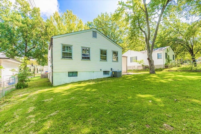 rear view of house featuring a yard and central AC