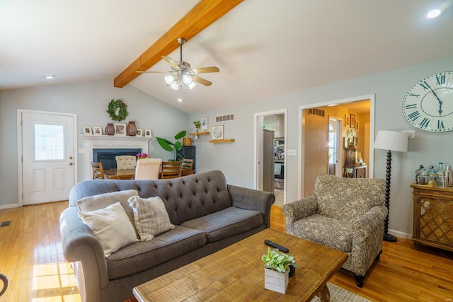 living room with ceiling fan, vaulted ceiling with beams, and wood-type flooring