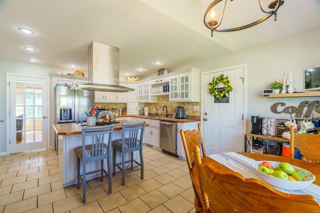 kitchen featuring extractor fan, appliances with stainless steel finishes, white cabinetry, and tasteful backsplash