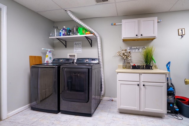 laundry area featuring light tile patterned floors, cabinets, and washer and dryer