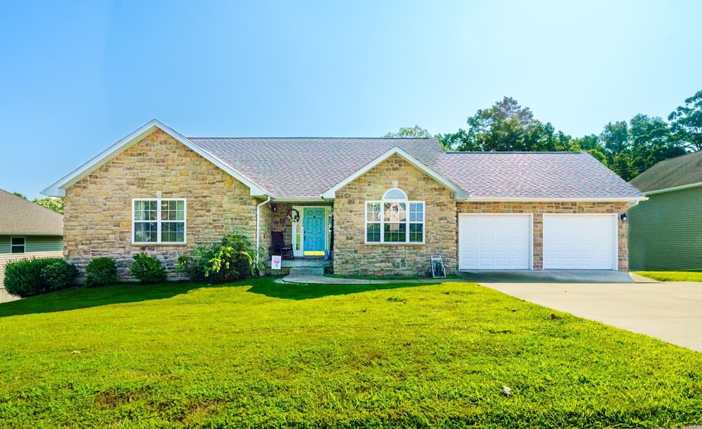 ranch-style home featuring a garage and a front lawn