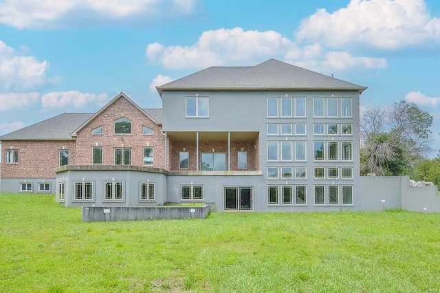 back of house featuring stucco siding, a yard, and fence