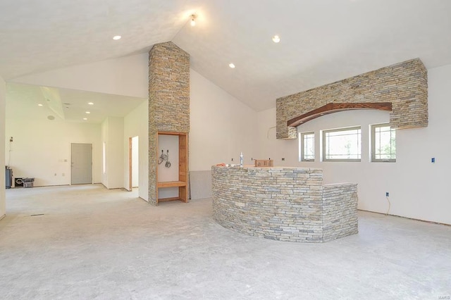 unfurnished living room featuring high vaulted ceiling