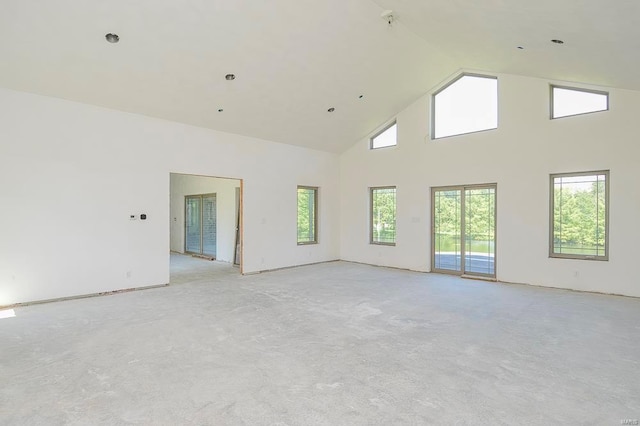 empty room featuring a healthy amount of sunlight and high vaulted ceiling