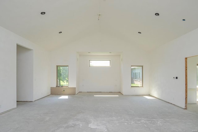 spare room featuring high vaulted ceiling and concrete floors