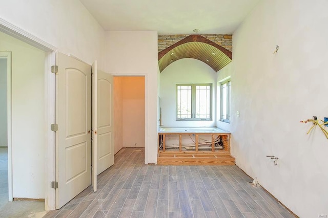 bathroom with lofted ceiling and wood finished floors
