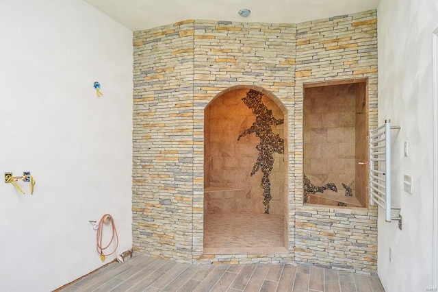 room details featuring arched walkways, wood finish floors, and radiator