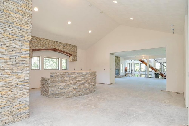 unfurnished living room featuring high vaulted ceiling and plenty of natural light