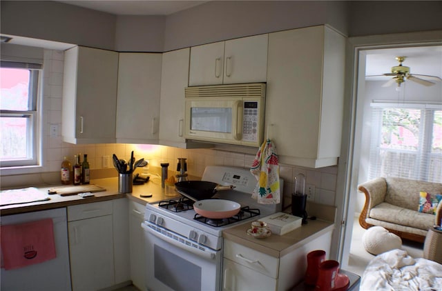 kitchen featuring ceiling fan, tasteful backsplash, white appliances, and white cabinets