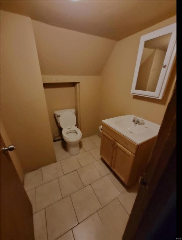 bathroom featuring tile patterned floors, vanity, lofted ceiling, and toilet