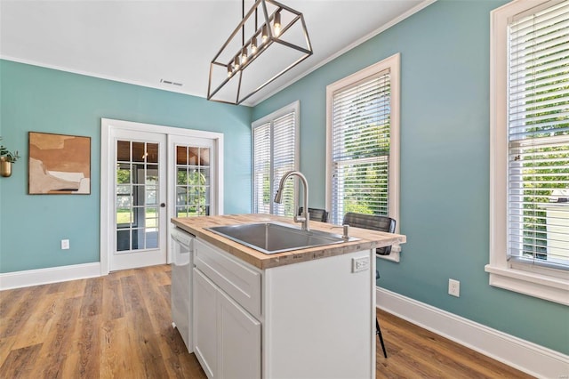 kitchen with french doors, white cabinets, a sink, an island with sink, and dishwasher