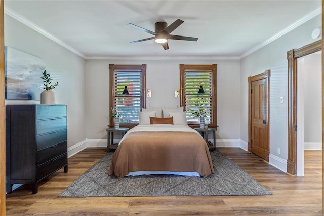 bedroom featuring baseboards, wood finished floors, and ornamental molding