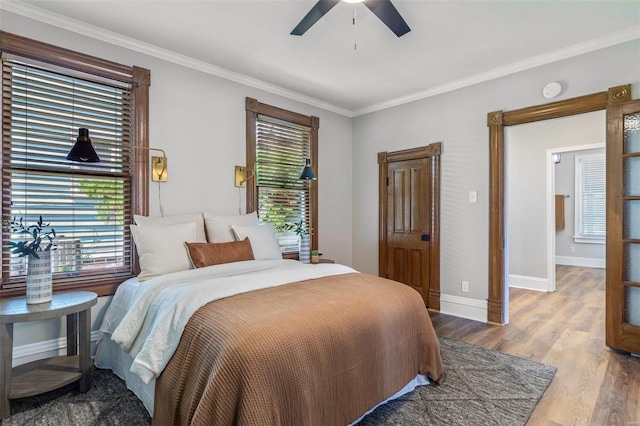 bedroom with baseboards, ornamental molding, ceiling fan, and wood finished floors