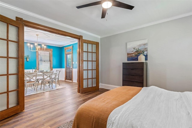 bedroom featuring ornamental molding, a chandelier, and wood finished floors