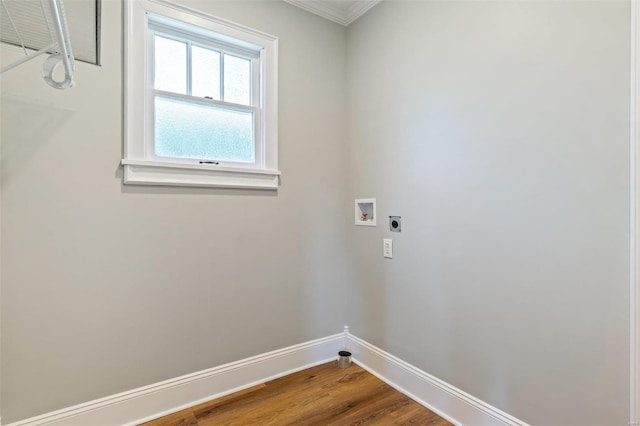 clothes washing area featuring hookup for a washing machine, hookup for an electric dryer, wood finished floors, laundry area, and baseboards