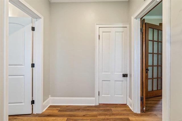 hallway featuring baseboards and wood finished floors