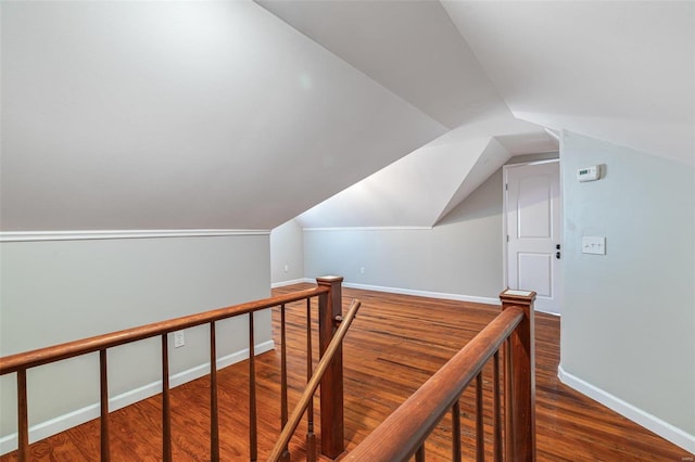 interior space with vaulted ceiling, wood finished floors, and baseboards