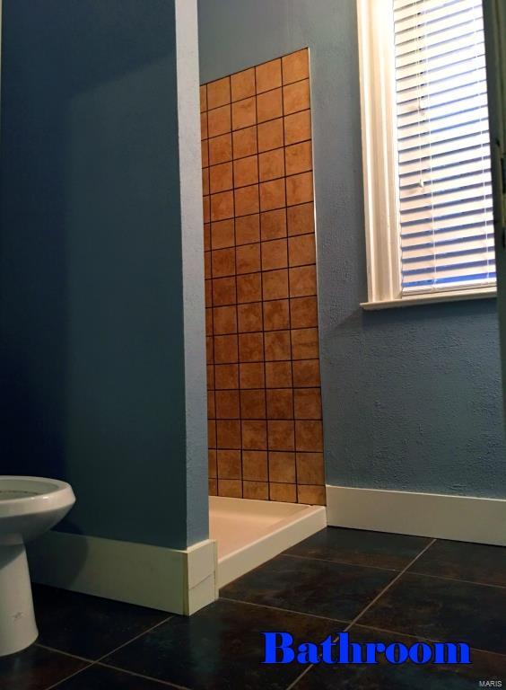 bathroom with toilet and tile patterned floors