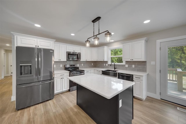 kitchen featuring white cabinetry, light countertops, appliances with stainless steel finishes, and a sink