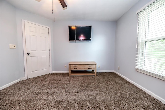 unfurnished bedroom with multiple windows, ceiling fan, and carpet flooring