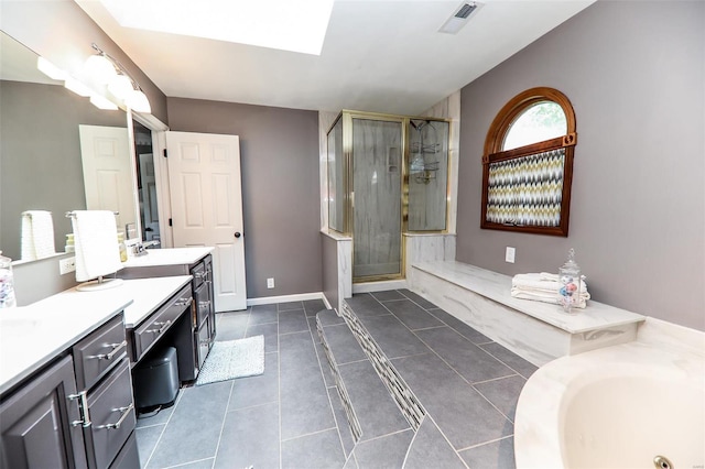 bathroom featuring vaulted ceiling with skylight, tile patterned flooring, vanity, and walk in shower