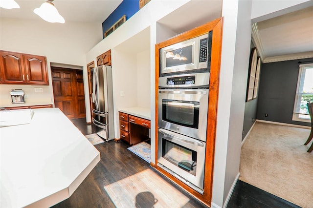 kitchen with dark carpet, sink, and stainless steel appliances