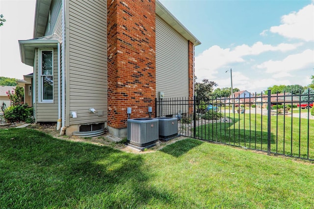 view of side of property with central air condition unit and a yard