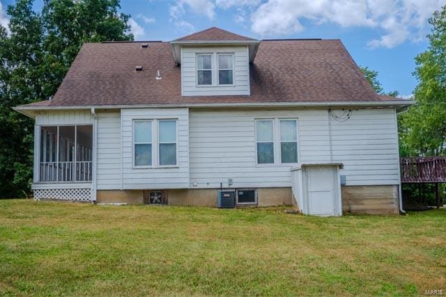 back of property with a lawn, a sunroom, and central air condition unit