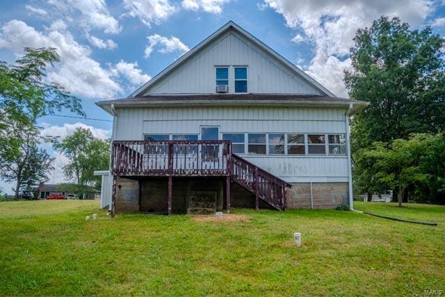 rear view of property featuring a lawn and a deck