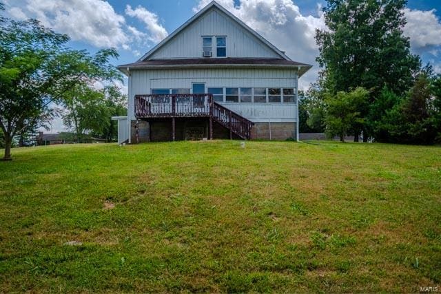 back of house featuring a wooden deck and a yard