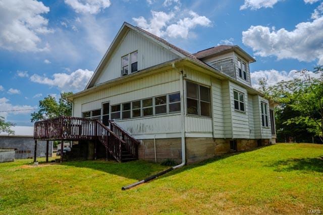 back of property with a yard and a deck