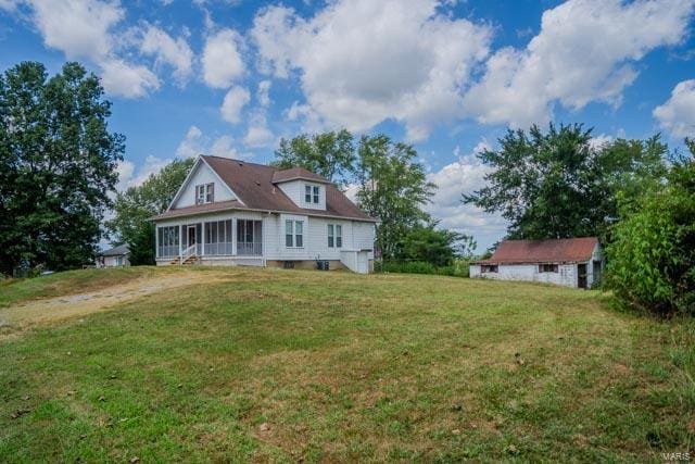 back of property with a lawn and a sunroom