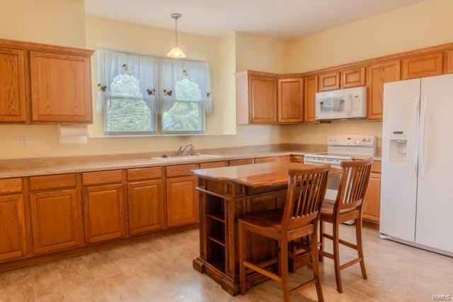 kitchen featuring sink, a kitchen island, pendant lighting, and white appliances