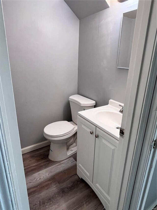 bathroom with hardwood / wood-style floors, toilet, and vanity