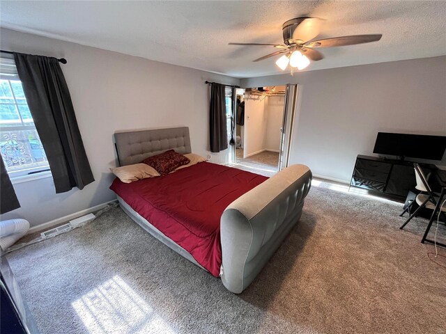 bedroom featuring ceiling fan, carpet flooring, and a textured ceiling