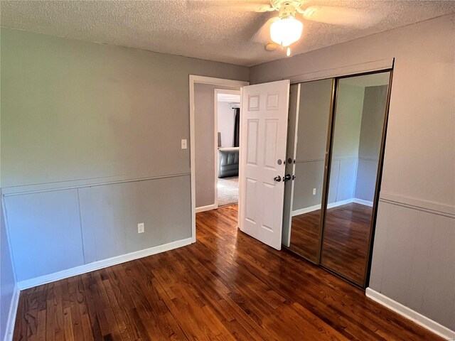 unfurnished bedroom with a textured ceiling, a closet, ceiling fan, and hardwood / wood-style floors