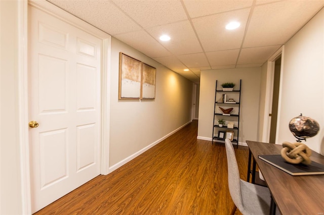 unfurnished office featuring a drop ceiling and dark hardwood / wood-style flooring