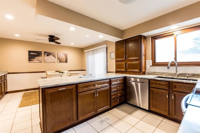 kitchen with kitchen peninsula, ceiling fan, dishwasher, light tile patterned flooring, and sink