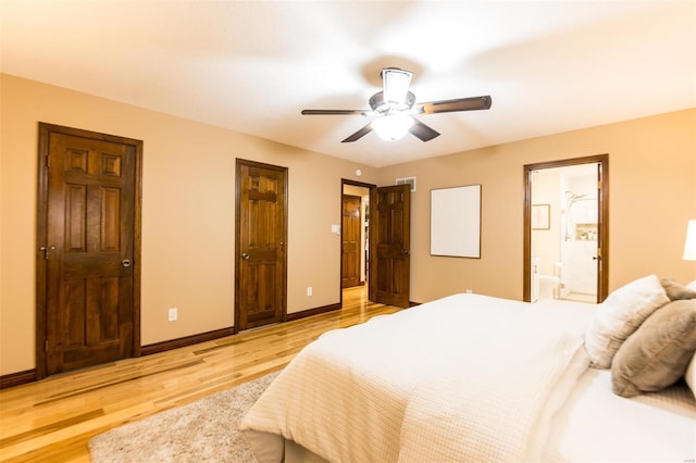 bedroom with ensuite bathroom, light wood-type flooring, and ceiling fan