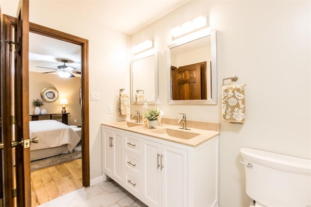 bathroom with toilet, hardwood / wood-style floors, vanity, and ceiling fan