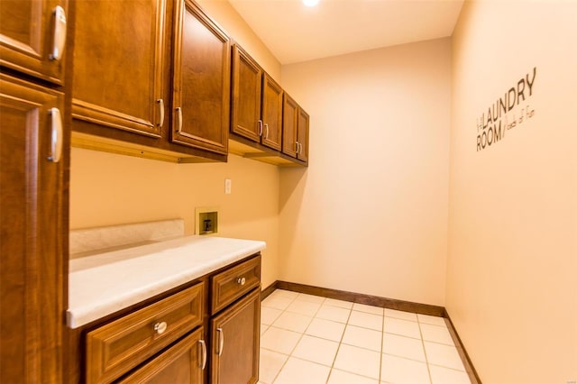 clothes washing area featuring washer hookup, light tile patterned floors, and cabinets