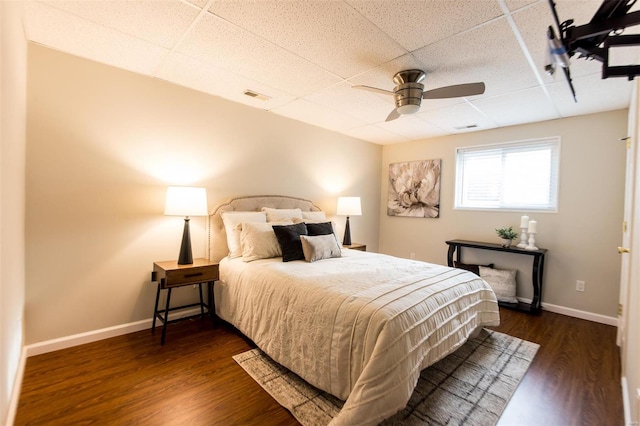 bedroom featuring dark hardwood / wood-style floors, a paneled ceiling, and ceiling fan