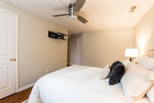 bedroom featuring a paneled ceiling, wood-type flooring, and ceiling fan