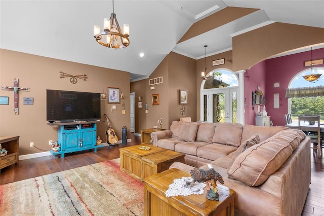 living area featuring an inviting chandelier, visible vents, dark wood-style flooring, and ornate columns