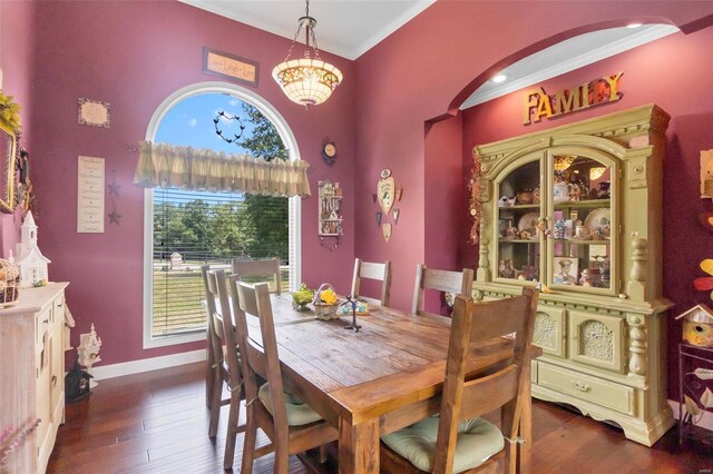 dining area with a notable chandelier, crown molding, and dark hardwood / wood-style floors