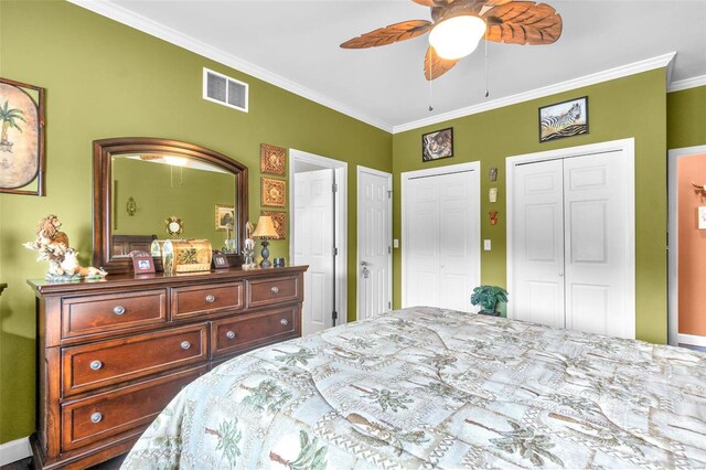 bedroom featuring ceiling fan, ornamental molding, and two closets