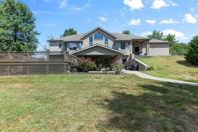 view of front of home featuring a deck, brick siding, and a front yard